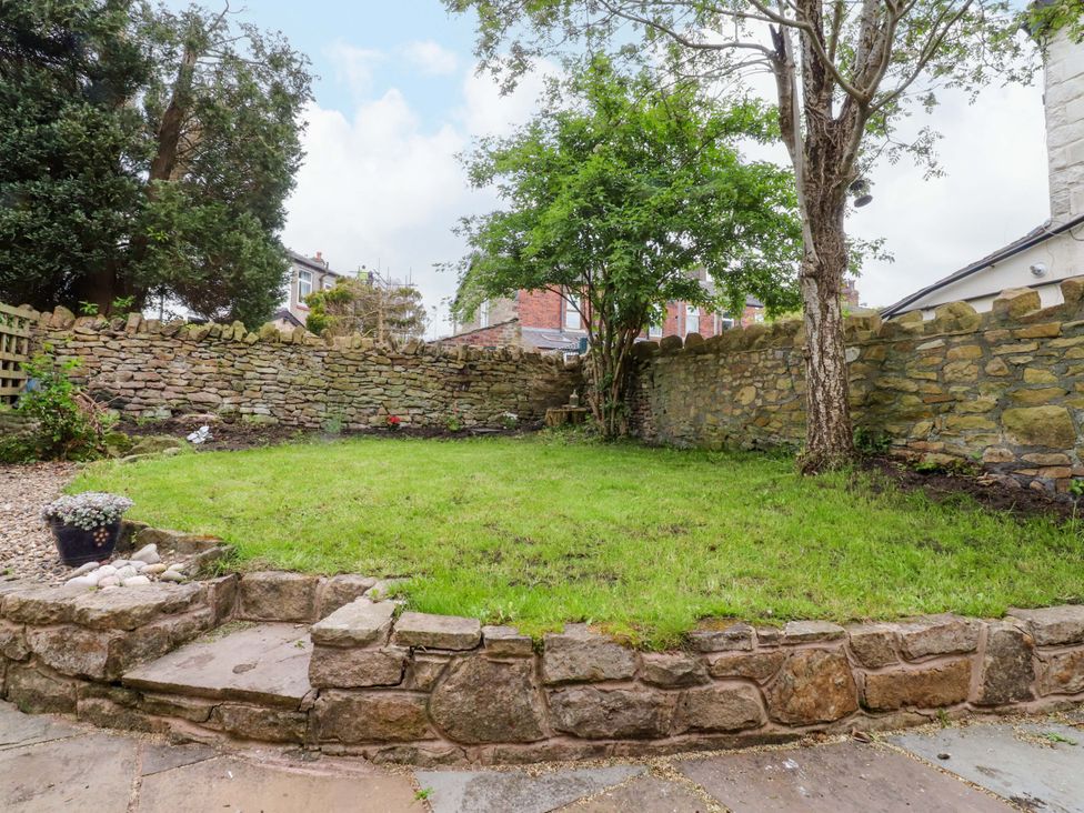 A garden with grass and stone wall at 6 Hazel Moor in Blackburn