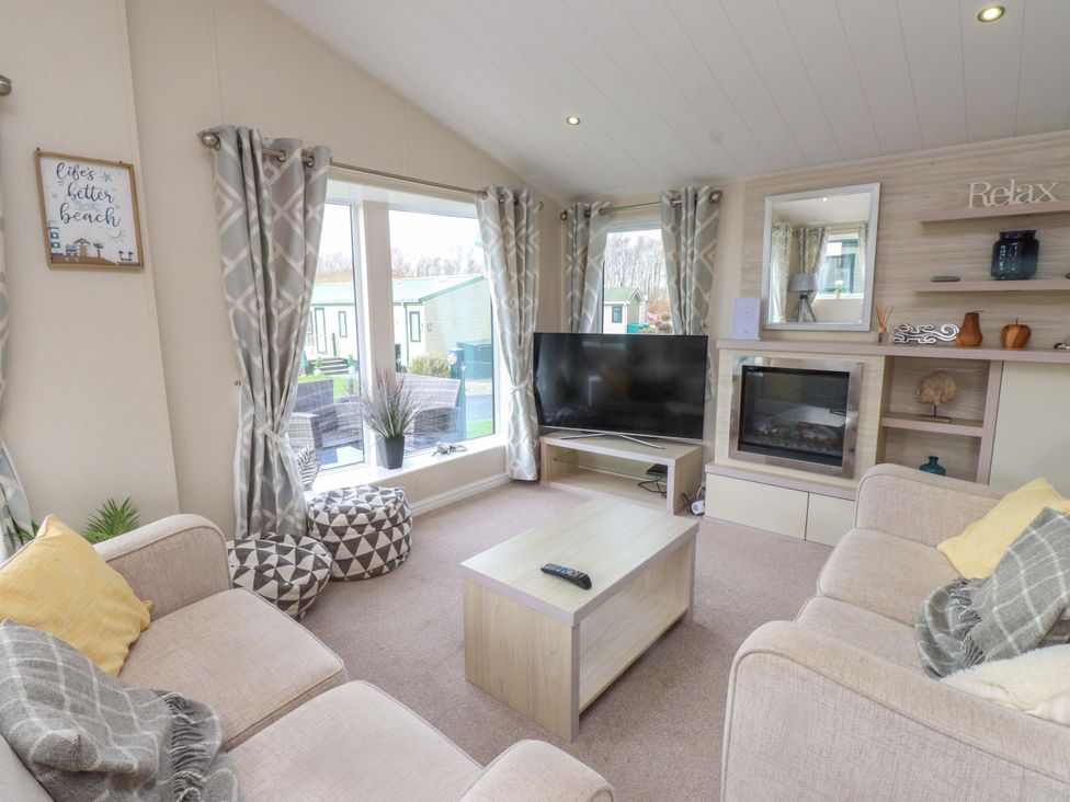 A living room with a television and seating area at 56 The Stables