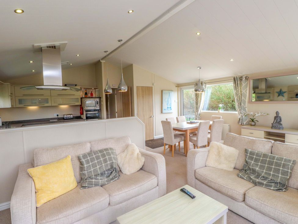 A living room with sofas and dining area at 56 The Stables