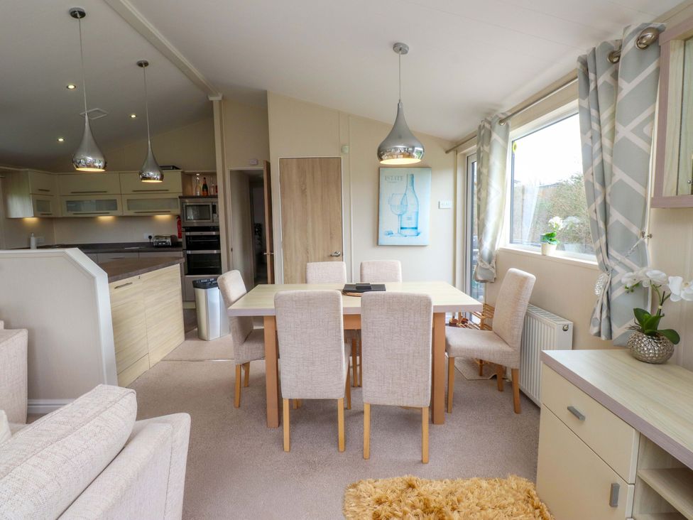 A dining room with a table and chairs at 56 The Stables