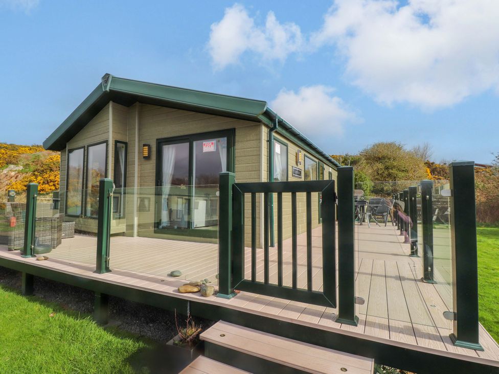An outdoor view of a lodge with decking and glass railing at 56 The Stables
