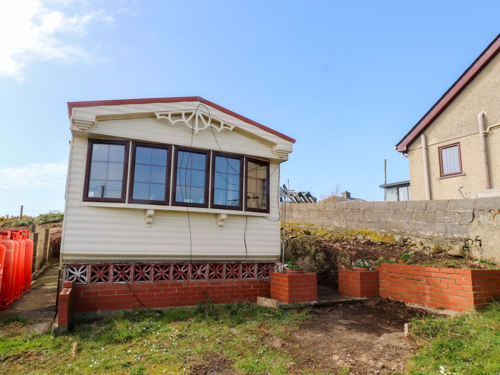 A caravan structure with windows outside at Caravan at Argraig Llanrhyddlad near Cemaes Bay