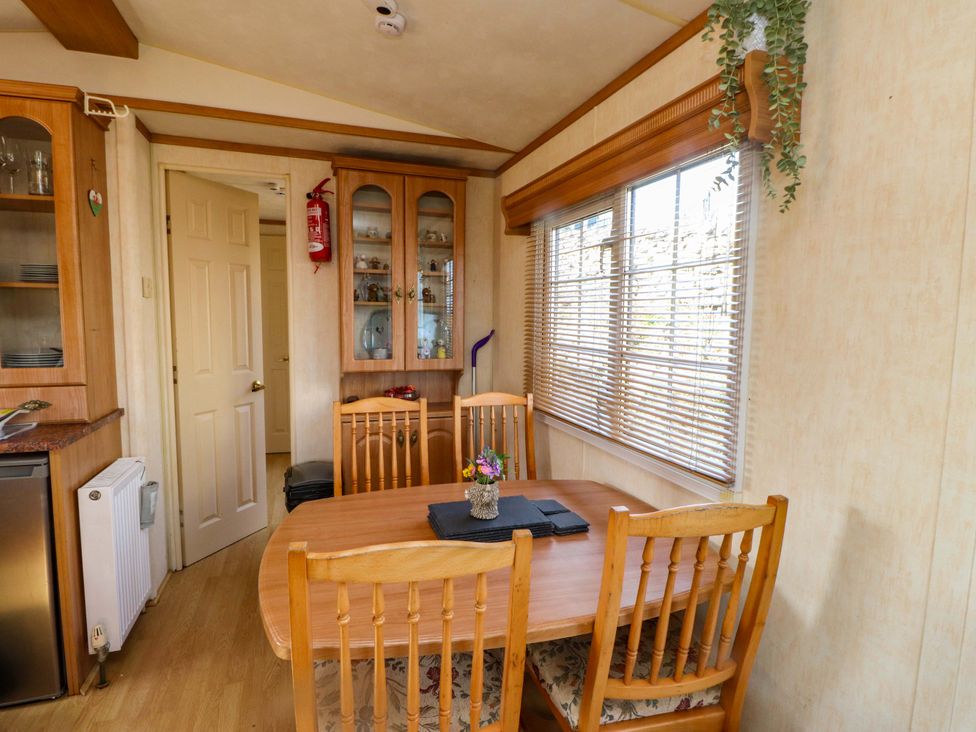 A dining room with a table and chairs at Caravan at Argraig Llanrhyddlad near Cemaes Bay