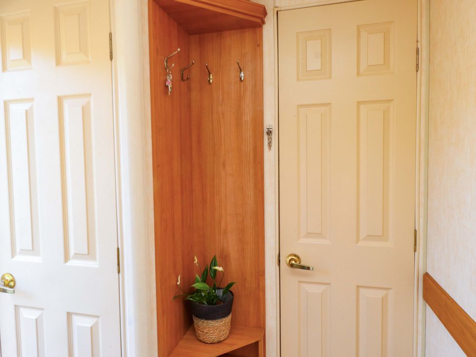 An entrance area with coat hooks and plant pot at Caravan at Argraig Llanrhyddlad near Cemaes Bay