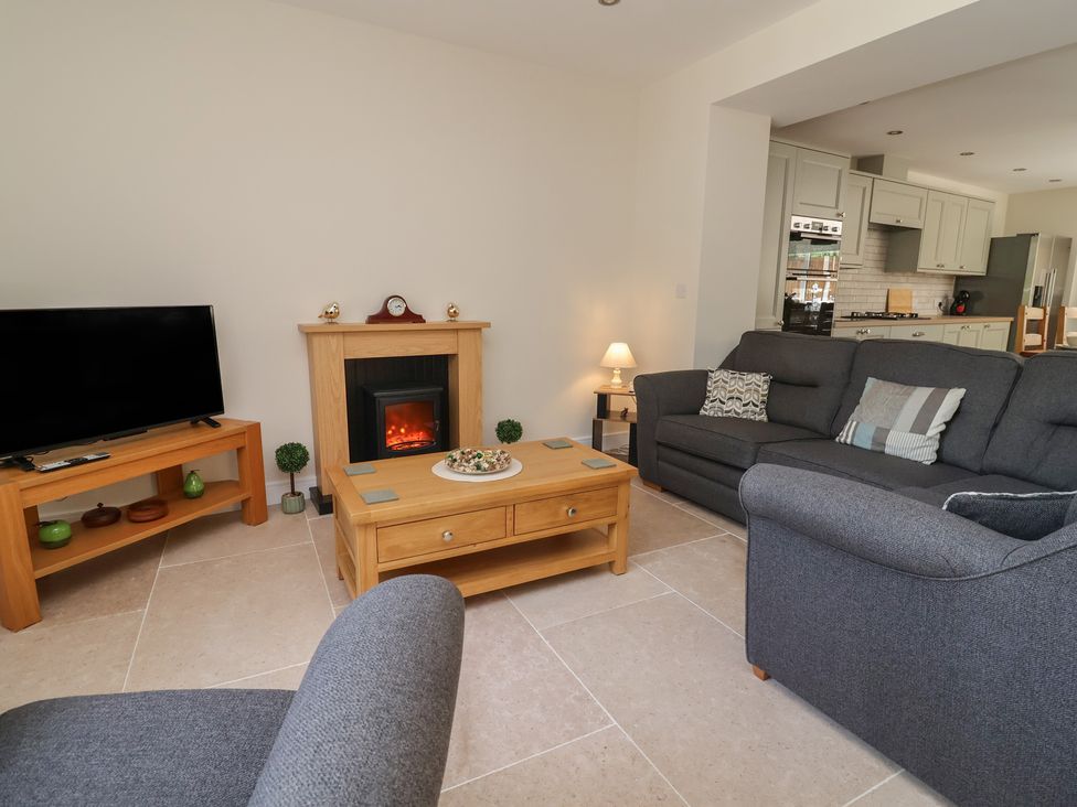 A living room with a sofa, television, and coffee table at Naseby House Morton near Alfreton