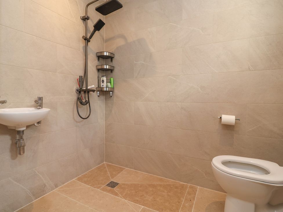 A bathroom featuring a sink, toilet, and shower at Naseby House in Morton near Alfreton