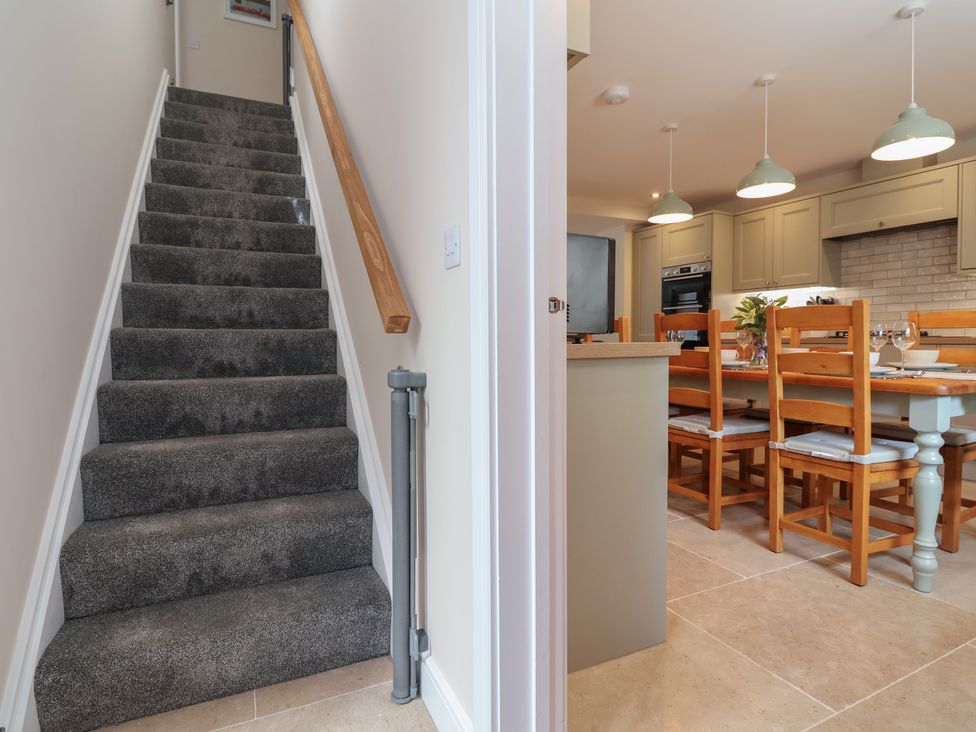 A kitchen with a dining table and chairs visible from the staircase at Naseby House in Morton near Alfreton