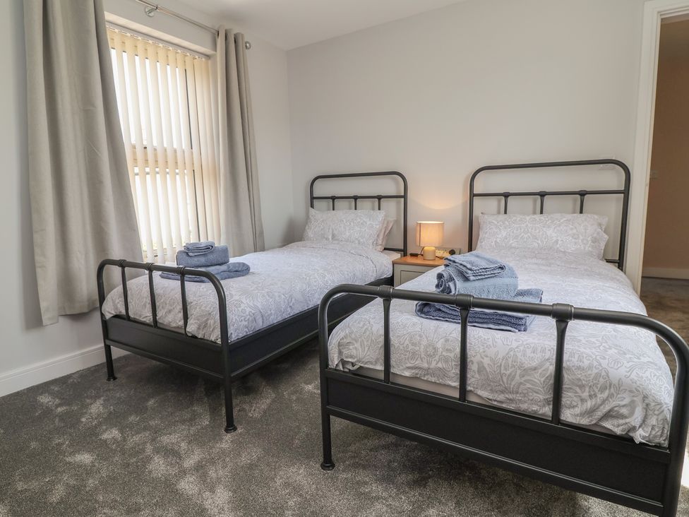 A bedroom with two single beds and a bedside table at Naseby House Morton near Alfreton