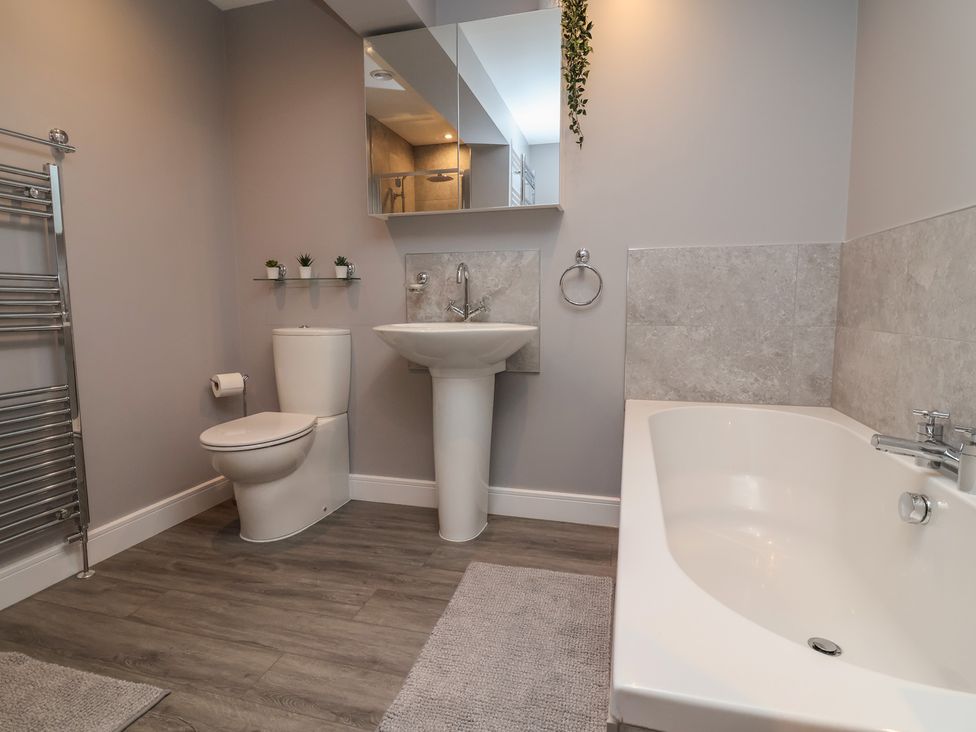 A bathroom with a toilet, sink and bathtub at Naseby House in Morton near Alfreton