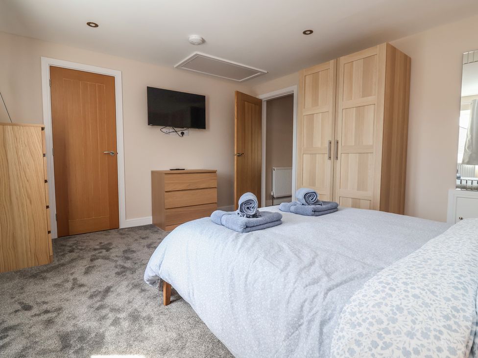 A bedroom with a bed and two towels on top at Naseby House in Morton near Alfreton