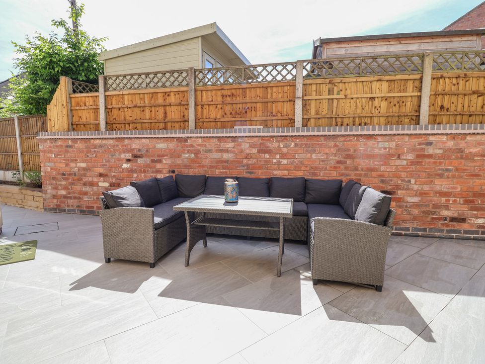 An outdoor seating area with an outdoor sofa and coffee table at Naseby House Morton near Alfreton