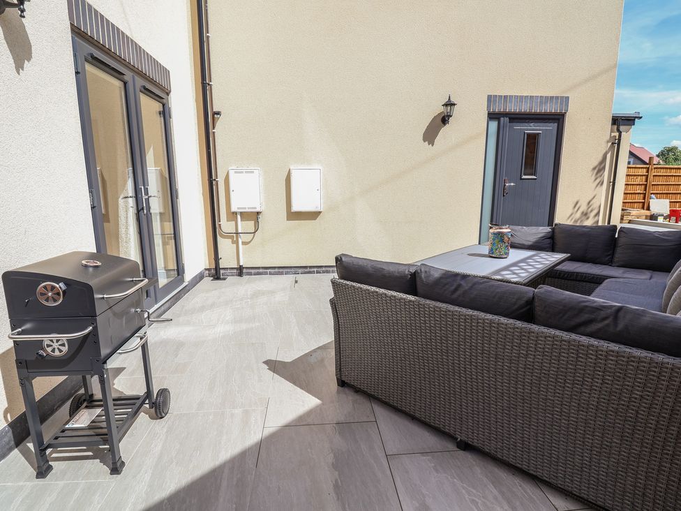An outdoor seating area with a barbecue grill and table at Naseby House in Morton near Alfreton