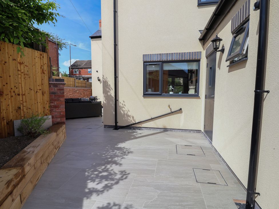 A garden patio area with steps and windows at Naseby House Morton near Alfreton