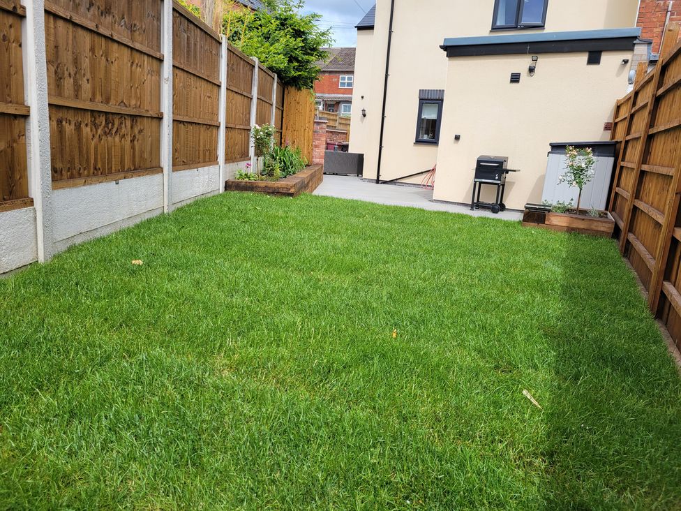 A garden with grass and a barbecue at Naseby House in Morton near Alfreton