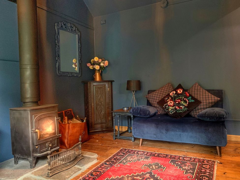 A living room with a sofa and fireplace at Ferryman's Lodge in Brockweir