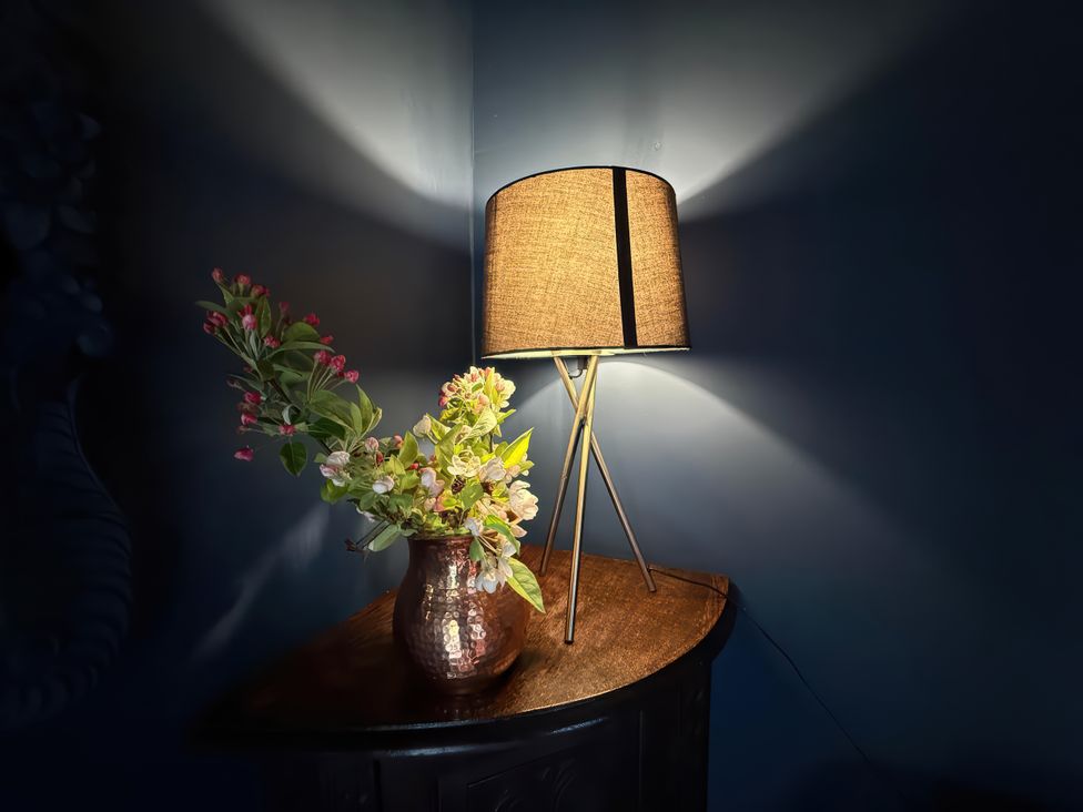 A lamp and a flower vase on a table at Ferryman's Lodge in Brockweir