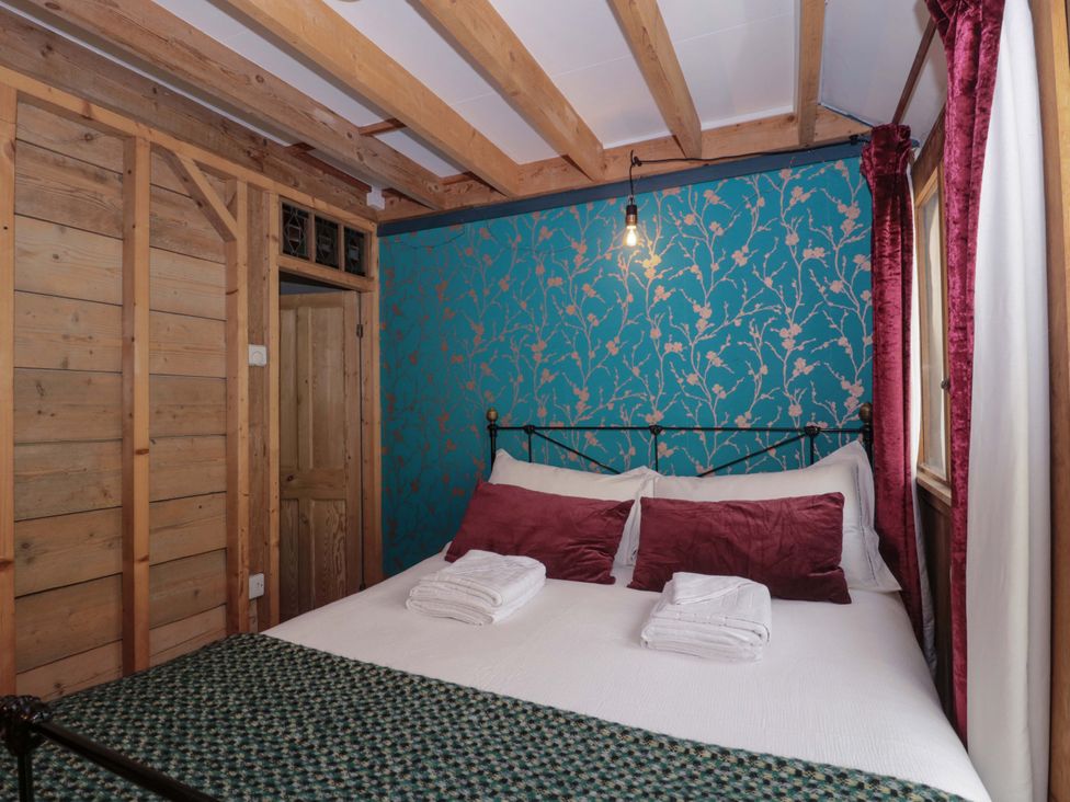 A bedroom with a bed and decorative wall at Ferryman's Lodge in Brockweir