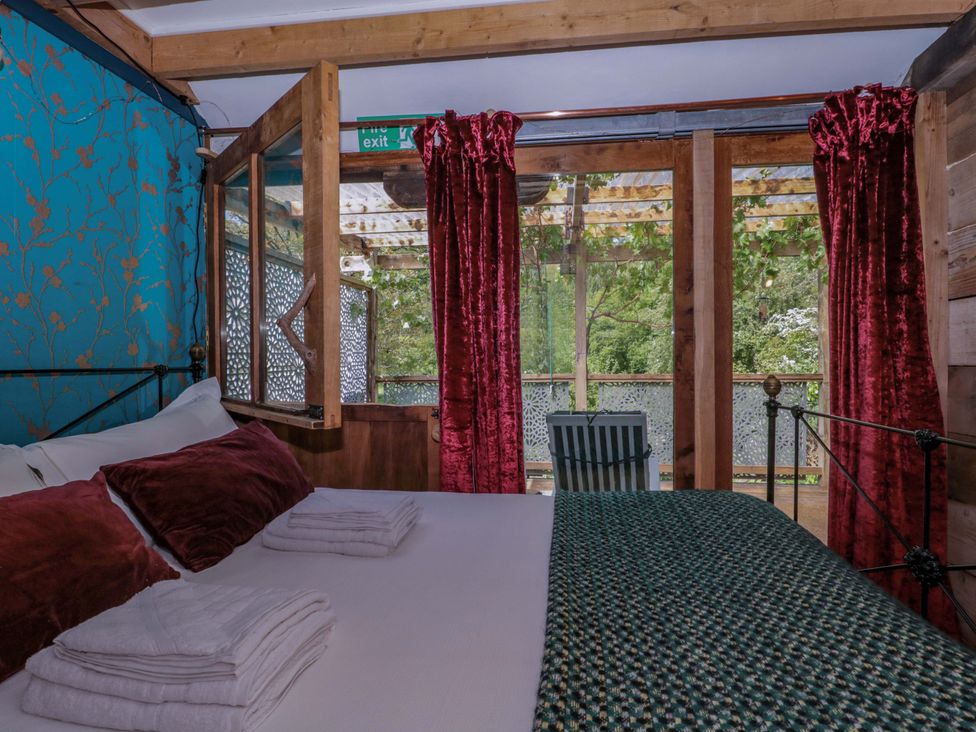 A bedroom with a bed and window at Ferryman's Lodge in Brockweir