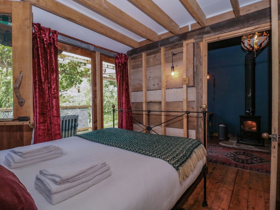 A bedroom with a bed and a stove at Ferryman's Lodge in Brockweir