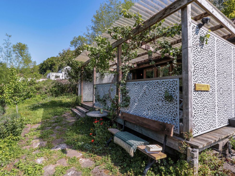 A garden with a decorative wall and seating at Ferryman's Lodge in Brockweir