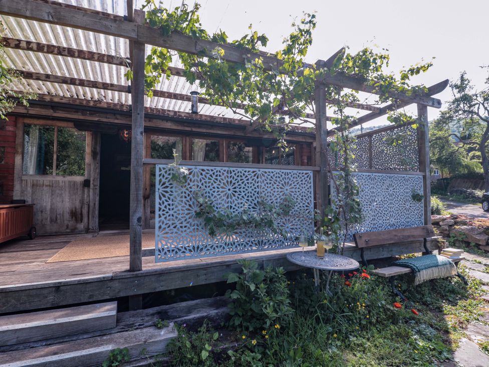 An outdoor area with a table and benches at Ferryman's Lodge in Brockweir