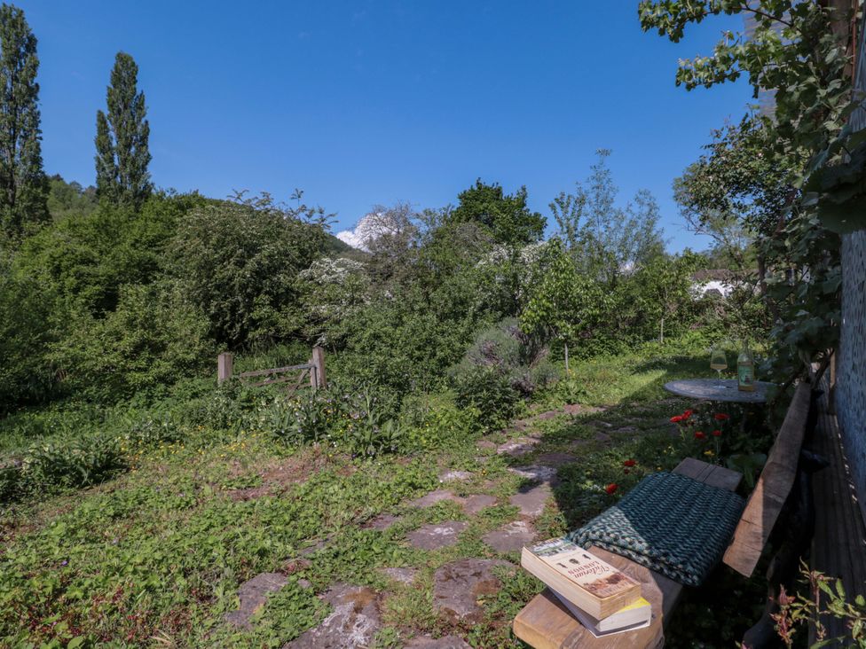 A garden with a bench and table at Ferryman's Lodge in Brockweir