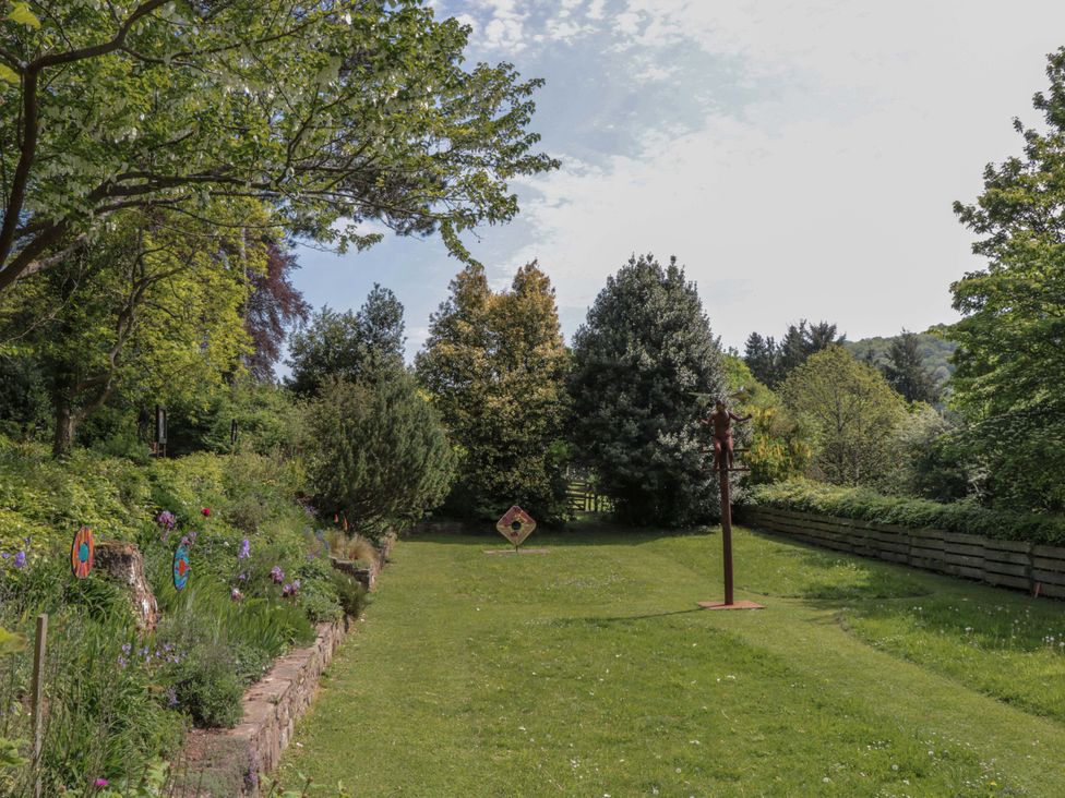 A garden with trees and sculptures at Ferryman's Lodge in Brockweir