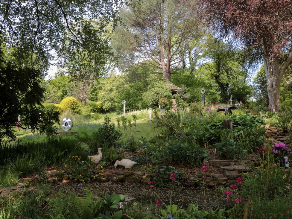 A garden with various plants and decorative elements at Ferryman's Lodge in Brockweir