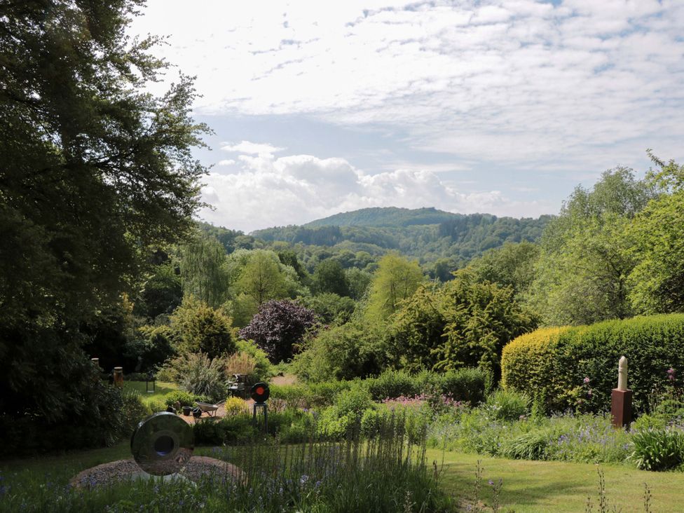 A garden with trees and sculptures at Ferryman's Lodge in Brockweir