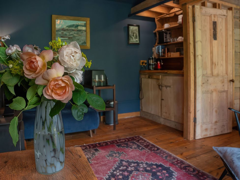 A living room with flowers on a table at Ferryman's Lodge in Brockweir