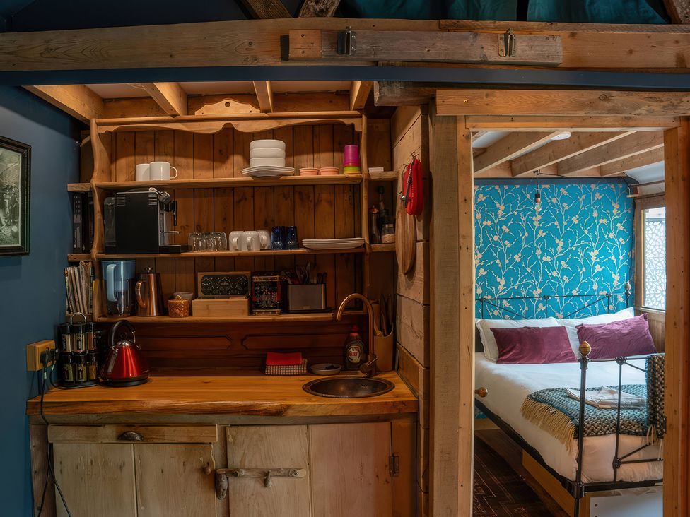 A kitchen with a sink and shelves at Ferryman's Lodge in Brockweir