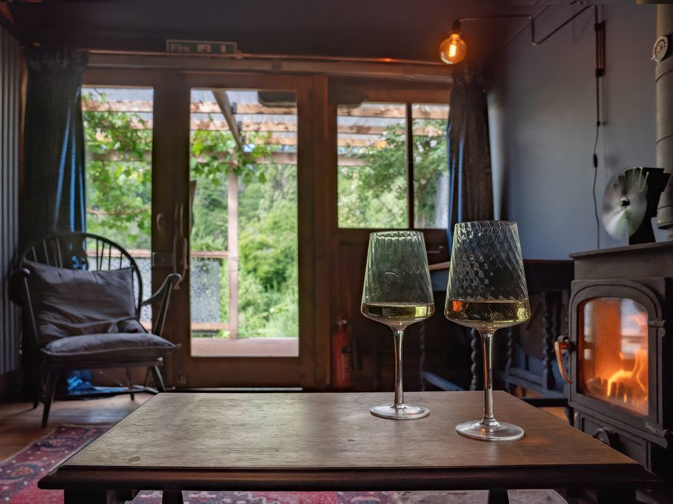 A living room with wine glasses on a table at Ferryman's Lodge in Brockweir