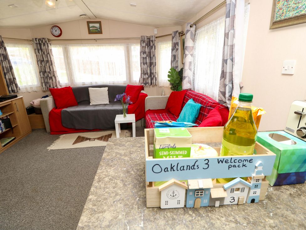 A living room with a sofa and a welcome pack at Oaklands 3 in Cowes