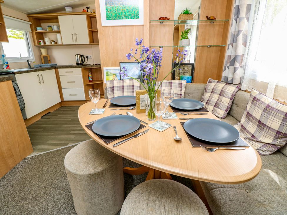 A dining room with a round table set for four at the Caravan in Cowes