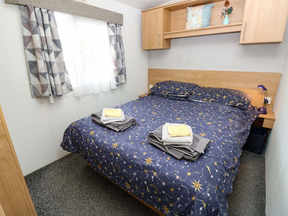 A bedroom with a double bed and towels at Caravan in Cowes