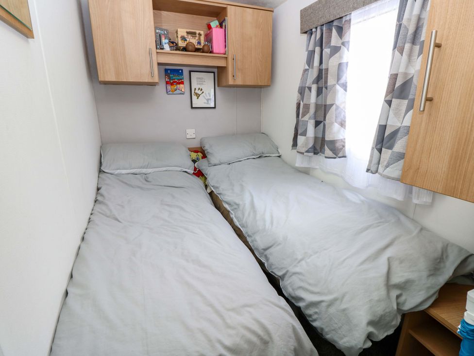 A bedroom with twin beds and shelves at Caravan in Cowes