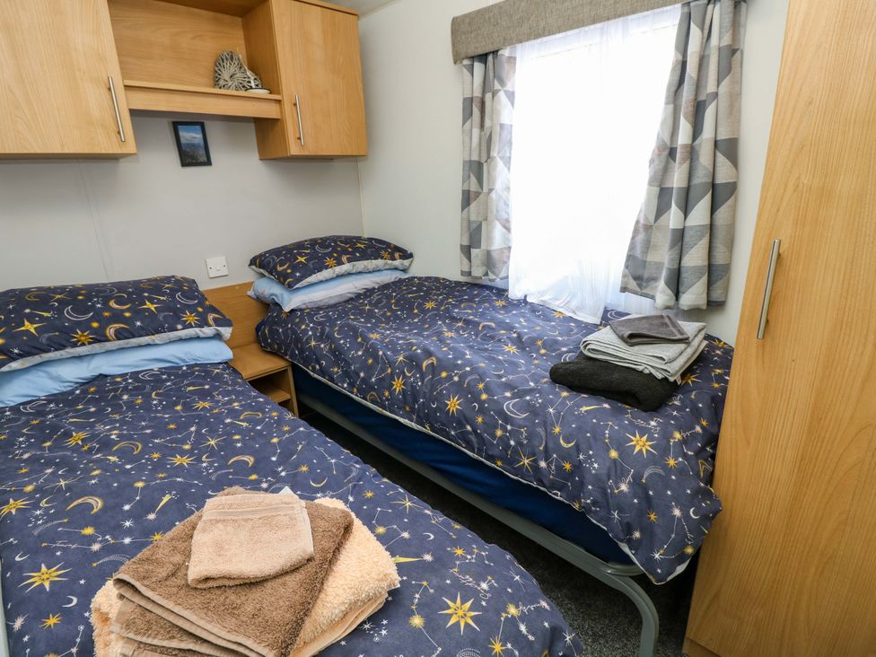 A bedroom with two beds and towels at Caravan in Cowes