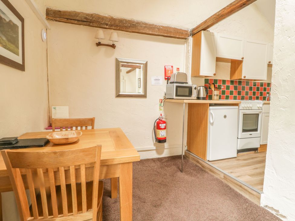 A kitchen with a table and chairs at Mews Cottage 5 Keswick