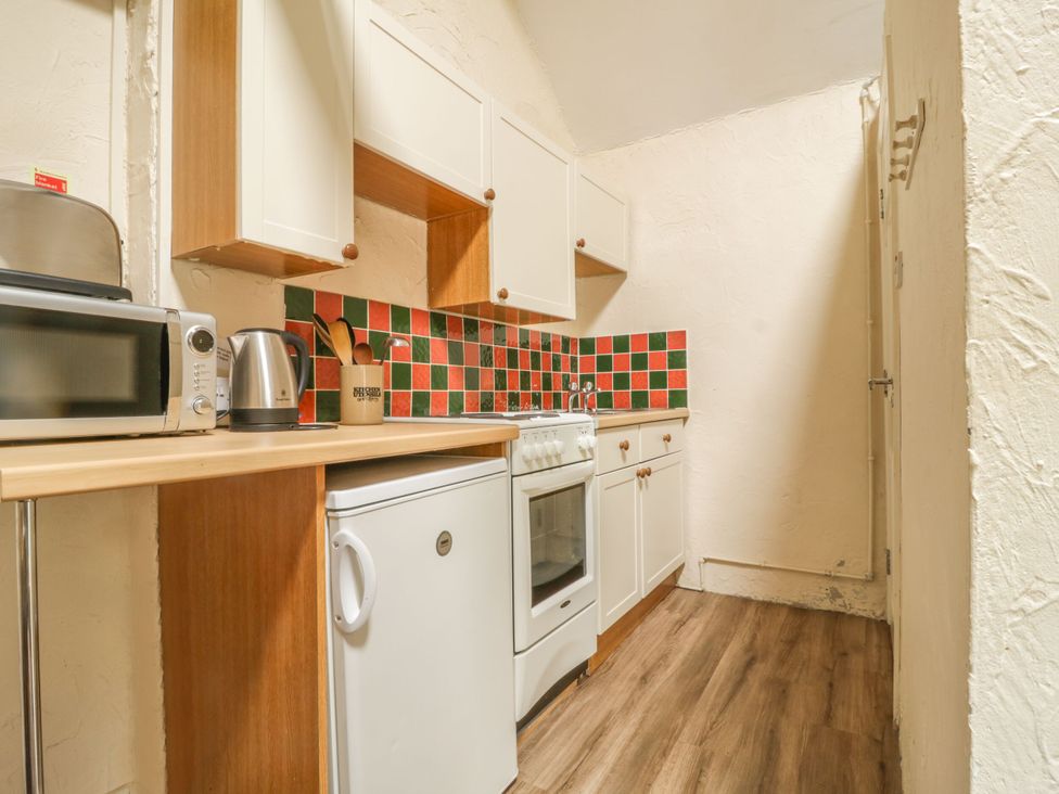 A kitchen with appliances and cabinets at Mews Cottage 5 in Keswick