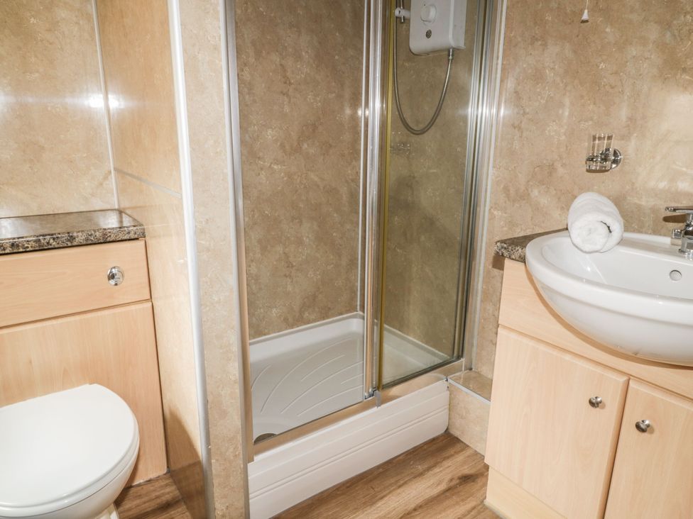 A bathroom with a shower, toilet and sink at Mews Cottage 5 in Keswick