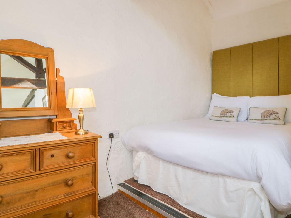 A bedroom with a bed and a dresser at Mews Cottage 6 Keswick