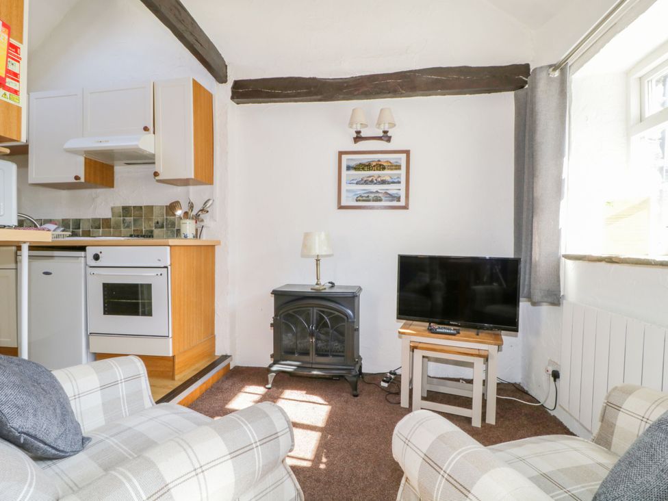 A living room with a sofa and television at Mews Cottage 6 in Keswick