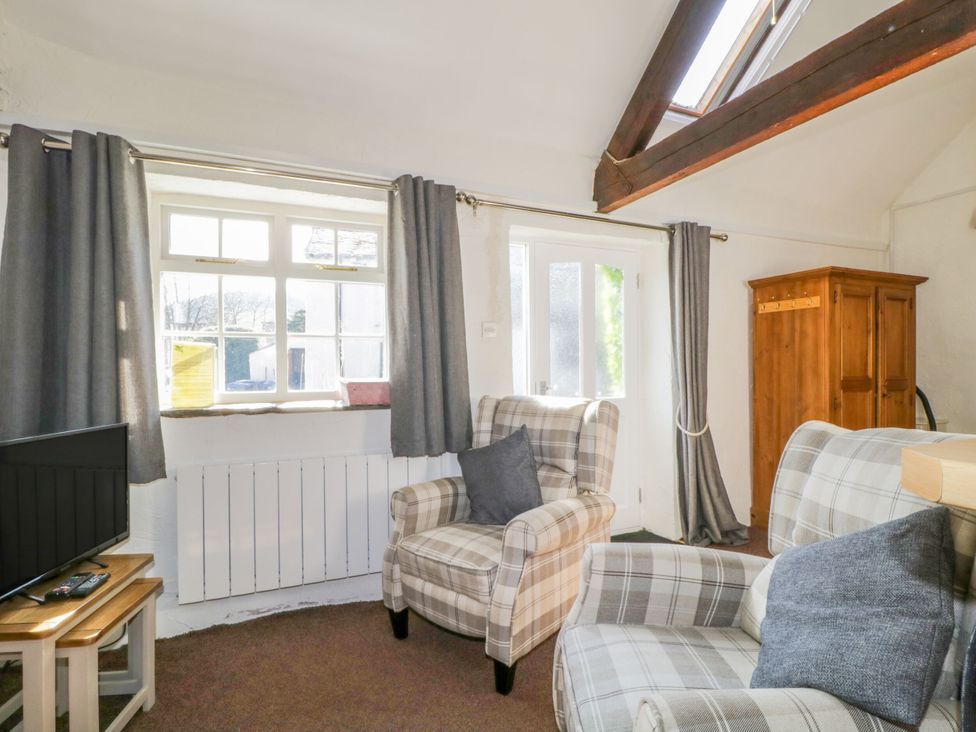 A living room with a sofa and armchair at Mews Cottage 6 in Keswick