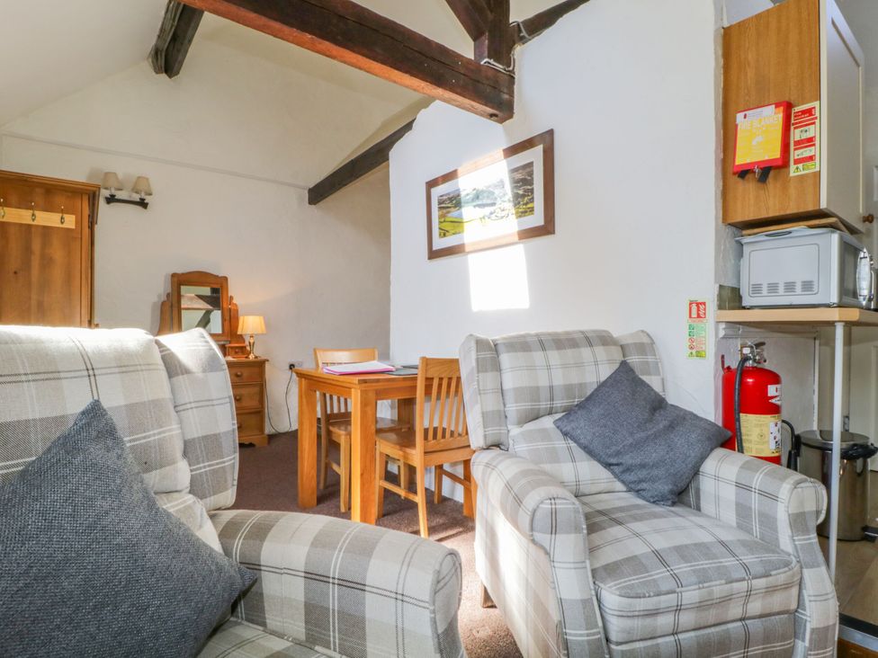 A living room with sofa and dining table at Mews Cottage 6 in Keswick