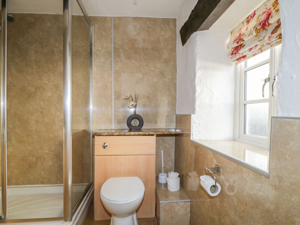 A bathroom with a shower and toilet at Mews Cottage 6 in Keswick