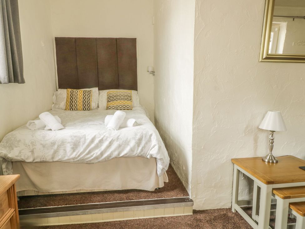 A bedroom with a bed and desk at Mews Cottage 7 Braithwaite