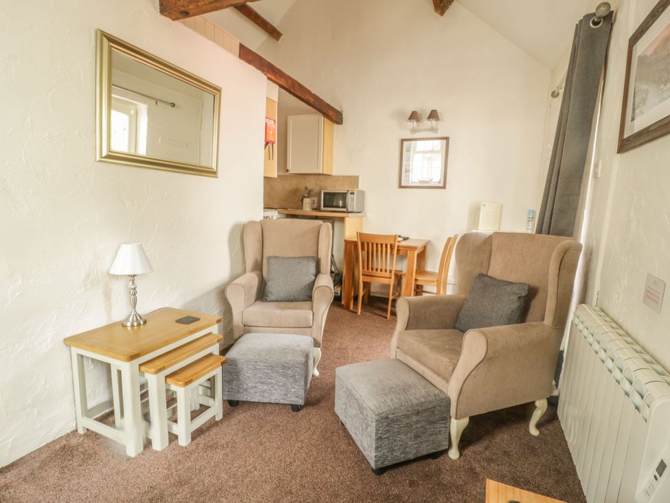 A living room with seating and dining area at Mews Cottage 7 Braithwaite
