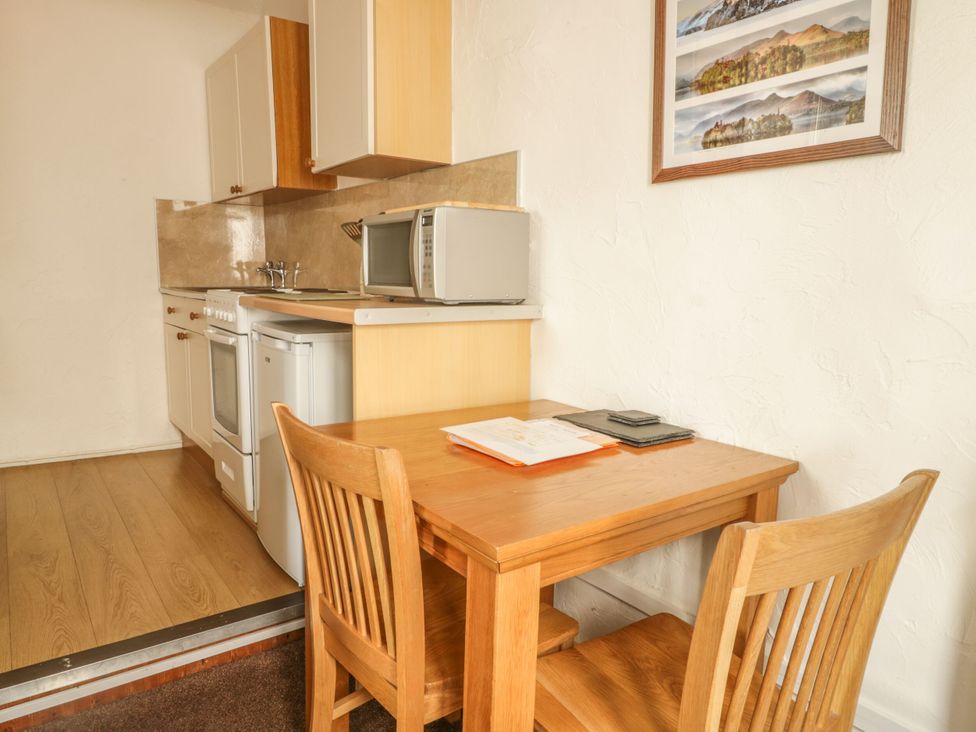 A kitchen with a table and chairs at Mews Cottage 7 Braithwaite