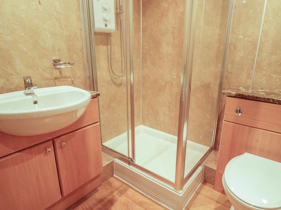 A bathroom with a sink, shower, and toilet at Mews Cottage 7 in Braithwaite