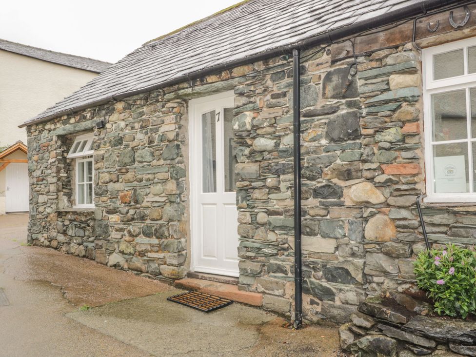 An exterior view of a stone cottage with a door and window at Mews Cottage 7 Braithwaite